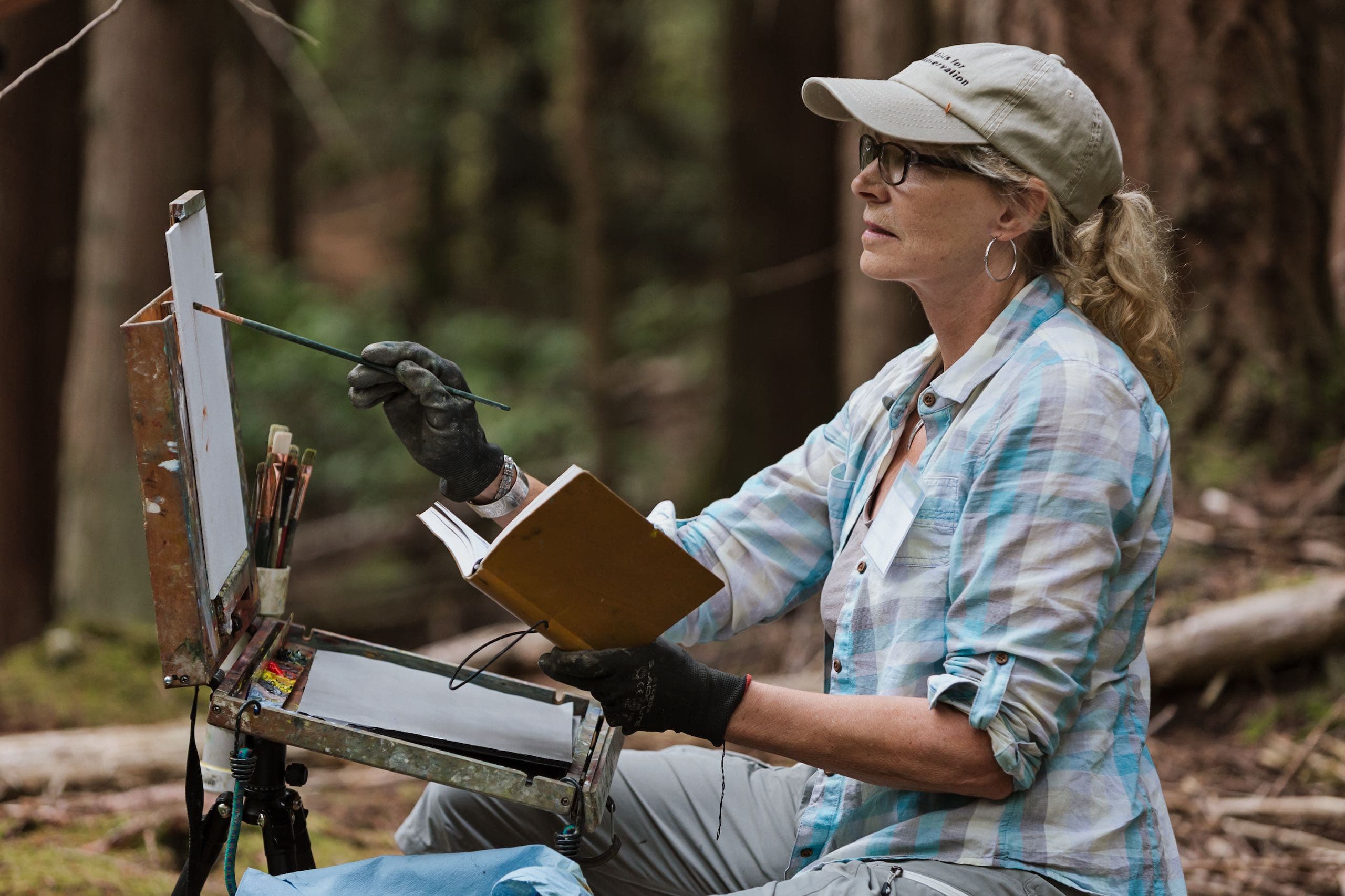 Gaye Adams painting in the woods