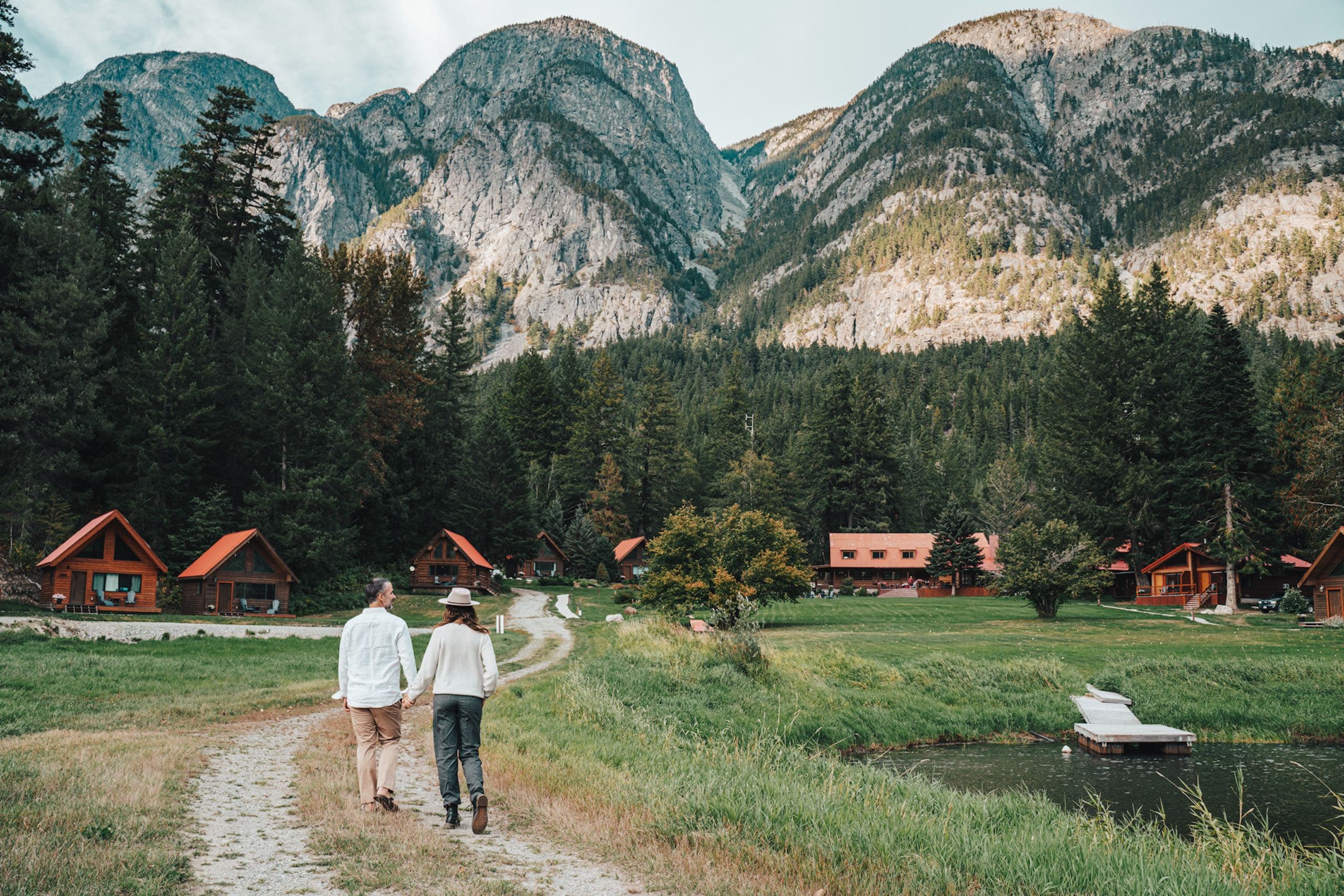 A couple holding hands walking towards the lodges