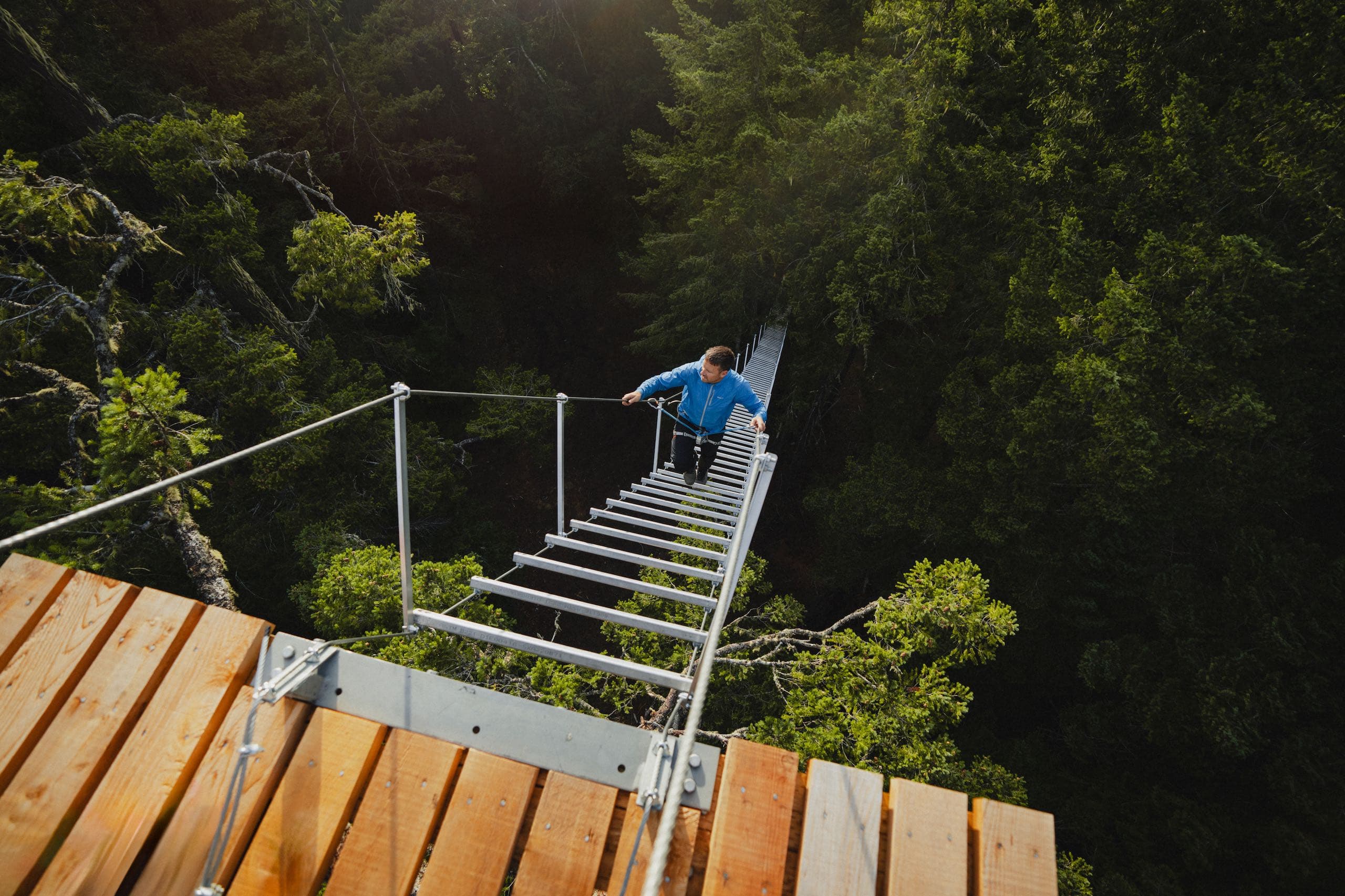 A man climbing up a rope stair case