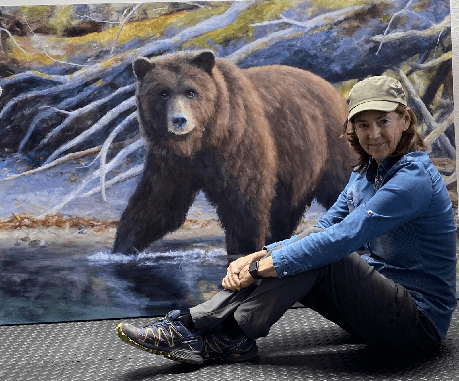 Doria Moodie sitting by a bear painting she did