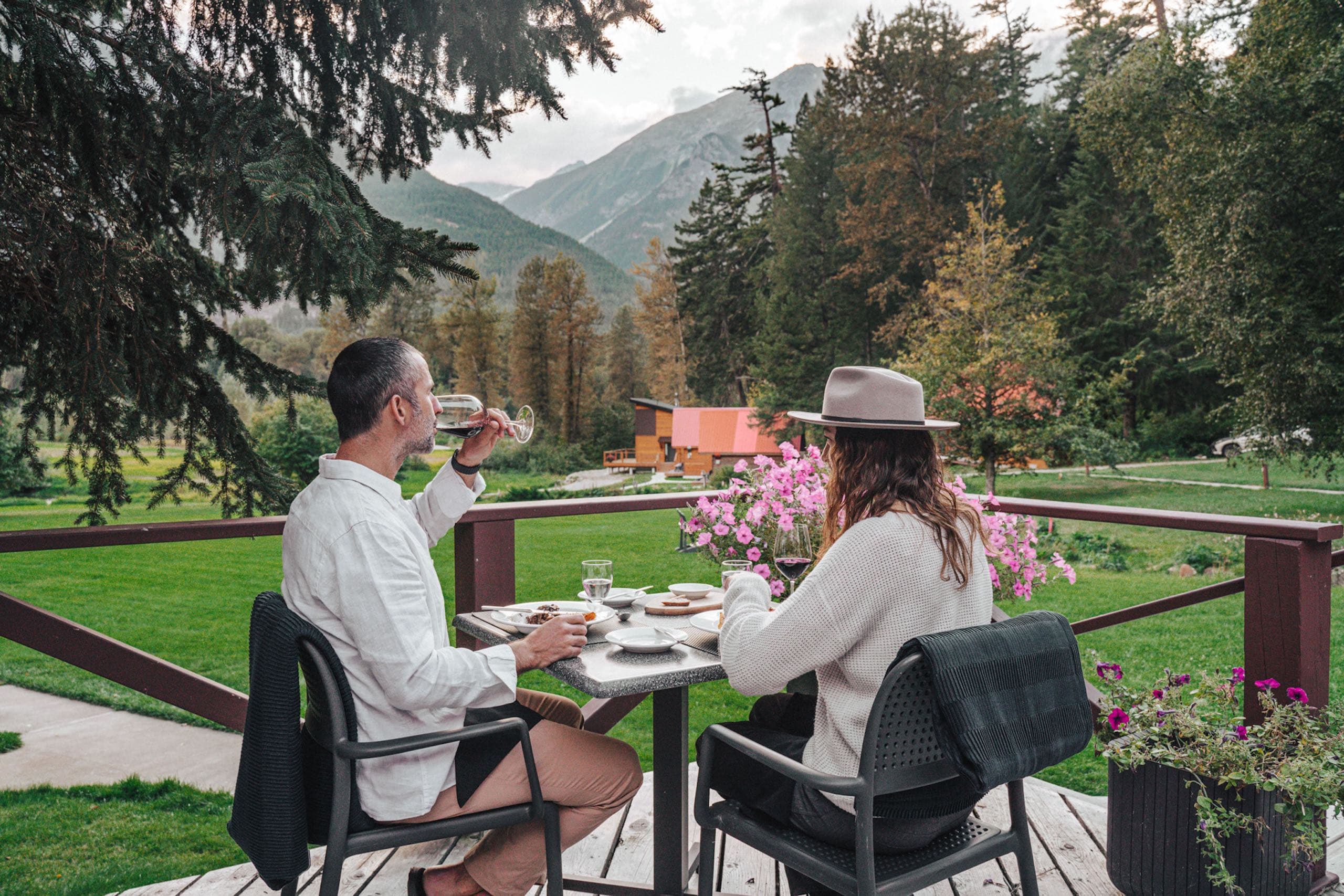 A couple enjoying dinner outside with a view of the lawn