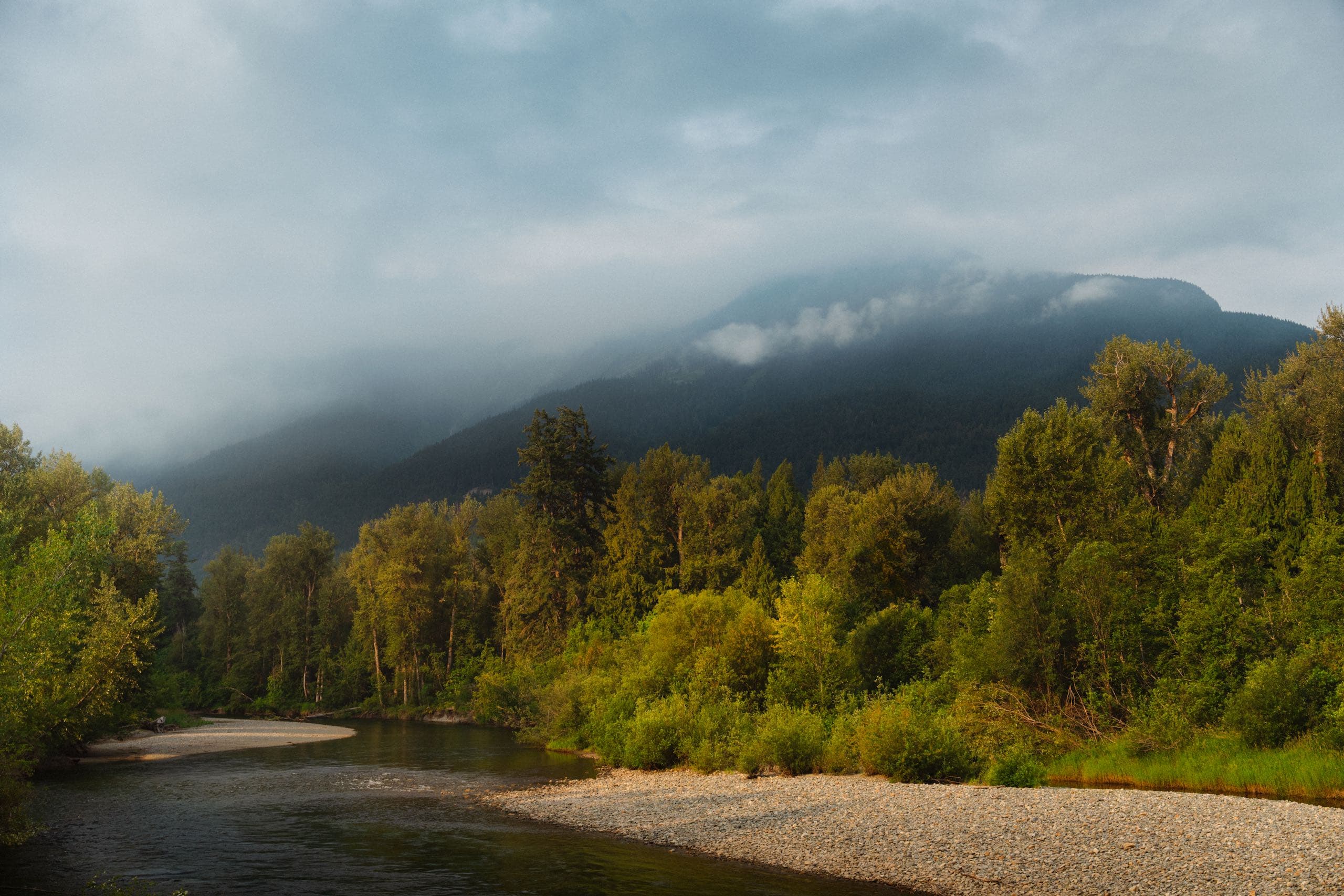 fog rolling in over the mountain by the river