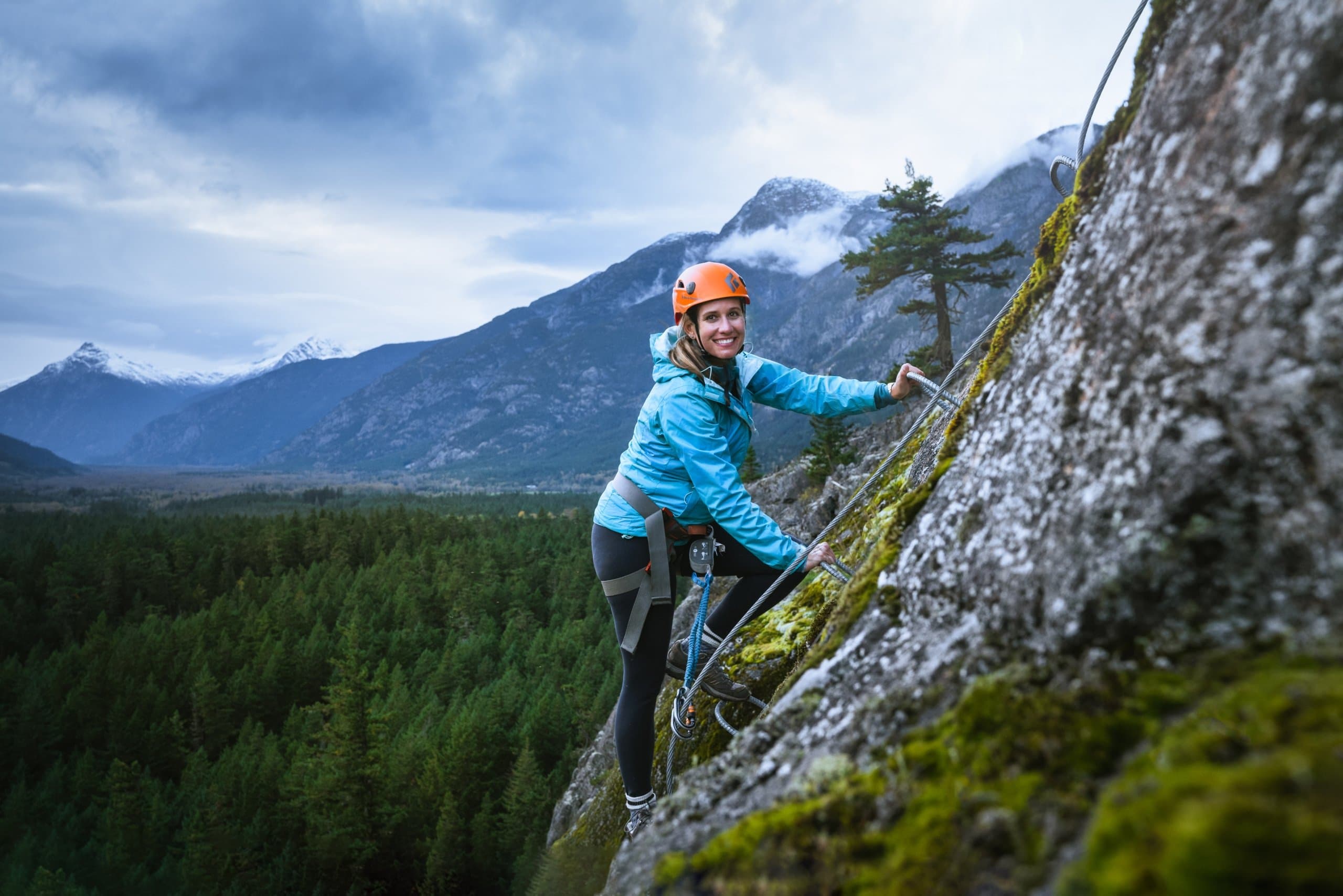 A woman on the side of a mountain smiling