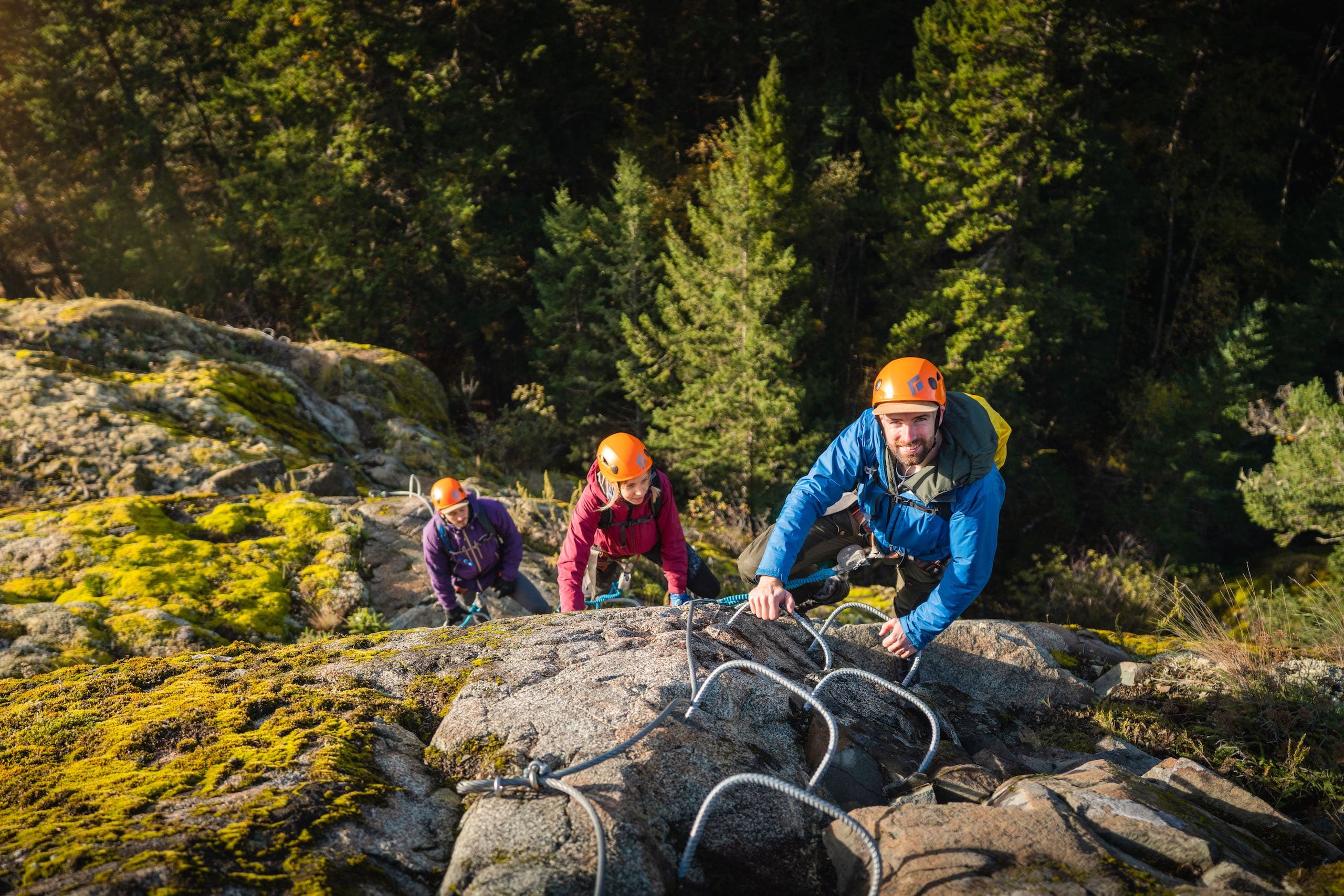 A group of people climbing a mountain on a rebar ladder